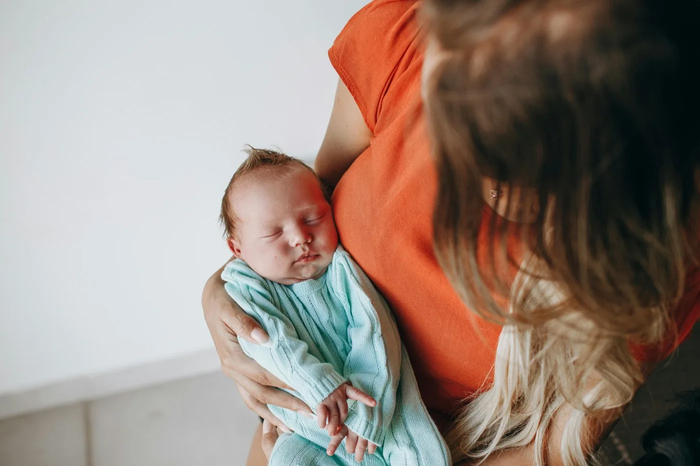 Newborn baby held gently in caring arms